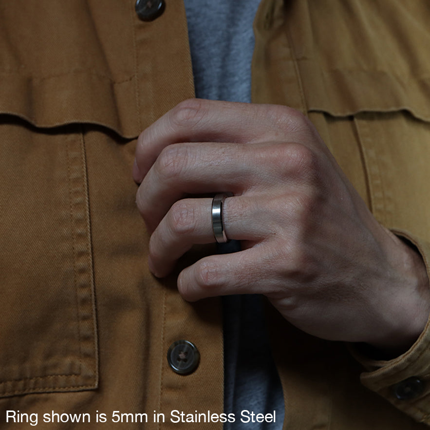 Stainless Steel ring with bevelled edge on hand, holding open shirt
